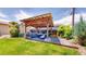 Outdoor living space features a covered pergola with ample seating and a fire pit at 1741 W 55Th Pl, Denver, CO 80221