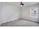 Neutral bedroom with ceiling fan, carpeted floor, and large window for natural light at 8211 Monte Vista Cir, Littleton, CO 80125