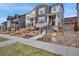 Beautiful townhouse featuring gray siding, stone accents, and a professionally landscaped front yard at 8211 Monte Vista Cir, Littleton, CO 80125