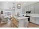 Open-concept kitchen with gray cabinets, a spacious island, and views into the living area at 8211 Monte Vista Cir, Littleton, CO 80125