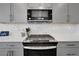 Detailed shot of kitchen appliances, including a modern stove and microwave, complemented by gray cabinetry at 8211 Monte Vista Cir, Littleton, CO 80125