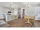 Open floor plan with a modern kitchen island, stainless appliances, and a view into the dining room at 8211 Monte Vista Cir, Littleton, CO 80125