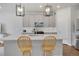 A bright kitchen with an island, pendant lighting, stainless steel appliances, grey cabinets, and white countertops at 8211 Monte Vista Cir, Littleton, CO 80125