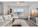 Cozy living room with a fireplace, large window with views, a ceiling fan, and a white sofa at 8211 Monte Vista Cir, Littleton, CO 80125