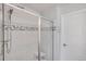 Glass shower with a built-in seat, chrome fixtures, and a tiled accent stripe at 8211 Monte Vista Cir, Littleton, CO 80125