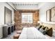 Charming bedroom with exposed brick wall, comfortable bed, and stylish decor for a relaxing retreat at 1435 Wazee St # 305, Denver, CO 80202