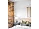 This relaxing bedroom setting showcases exposed brick detail alongside a comfortable bed and modern décor at 1435 Wazee St # 305, Denver, CO 80202