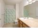 Bright bathroom featuring large mirror, cabinets, and shower with leaf-patterned curtain at 22675 E Ontario Dr # 202, Aurora, CO 80016