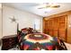Comfortable bedroom with wood paneled accent wall and closet doors and attractive bedding at 2268 Jay St, Edgewater, CO 80214