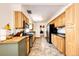 Galley kitchen with tiled floor, wood cabinets, stone countertops, stainless appliances, and view to connecting room at 2268 Jay St, Edgewater, CO 80214