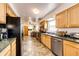 Functional kitchen with stainless steel appliances, wooden cabinetry, and a view into the dining area at 2268 Jay St, Edgewater, CO 80214