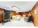 Living room with wood-paneled walls, neutral carpet, sofas, and a treadmill at 2268 Jay St, Edgewater, CO 80214