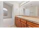 Bathroom featuring a large mirror, vanity with cabinets, and an arched window at 8623 E Dry Creek Rd # 423, Englewood, CO 80112