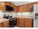 A well-lit kitchen featuring stainless steel appliances and wood cabinetry at 8623 E Dry Creek Rd # 423, Englewood, CO 80112