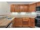 Kitchen features wood cabinets, stainless steel appliances, granite countertops, and tile flooring at 8623 E Dry Creek Rd # 423, Englewood, CO 80112