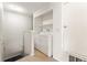 Bright laundry area featuring a stacked washer and dryer with shelving above for optimal organization and storage at 8623 E Dry Creek Rd # 423, Englewood, CO 80112