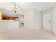 View of the living room, front door and open kitchen, illuminated by a modern chandelier at 8623 E Dry Creek Rd # 423, Englewood, CO 80112