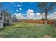 Large backyard with a wooden fence, well-maintained lawn, and mature trees at 215 Jay St, Lakewood, CO 80226