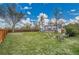 Expansive backyard featuring a fire pit, chairs, and a wooden fence under a sunny sky at 215 Jay St, Lakewood, CO 80226