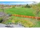 View of fenced backyard with fire pit, grassy area, and deck with outdoor grill and table at 215 Jay St, Lakewood, CO 80226