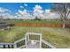 Backyard from deck with a well-maintained lawn, a wooden fence, and a grassy field beyond at 215 Jay St, Lakewood, CO 80226