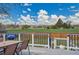 Outdoor deck featuring a dining table and chairs with views of a grassy field and blue skies at 215 Jay St, Lakewood, CO 80226