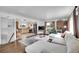 Open-concept living room and kitchen featuring hardwood floors, a brick accent wall, and modern furnishings at 215 Jay St, Lakewood, CO 80226