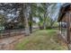 Green backyard featuring mature trees, a patio area, and a wooden fence at 17390 E Greenwood Cir, Aurora, CO 80013