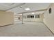 Expansive basement featuring neutral carpet, multiple windows, and storage shelves at 17390 E Greenwood Cir, Aurora, CO 80013
