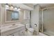 Well-lit bathroom with a frosted glass shower and ample vanity space at 17390 E Greenwood Cir, Aurora, CO 80013