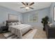 Serene bedroom featuring blue walls, a ceiling fan, a window with tree views, and contemporary decor at 17390 E Greenwood Cir, Aurora, CO 80013