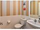 Stylish powder room with wainscoting, vertical striped wallpaper, and modern fixtures at 3401 N Xenia St, Denver, CO 80238