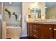 Bright bathroom featuring double vanity, framed mirrors, soaking tub, and decorative accents at 3401 N Xenia St, Denver, CO 80238