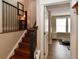 Interior staircase featuring wooden steps, metal railings, and access to an upstairs room with a treadmill at 3401 N Xenia St, Denver, CO 80238