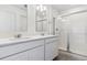 Modern bathroom featuring double sinks, white countertops, and a glass-enclosed shower at 17969 Dandy Brush Ln, Parker, CO 80134