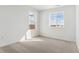 A bright, neutral bedroom featuring plush carpet and two windows showcasing scenic views at 17969 Dandy Brush Ln, Parker, CO 80134