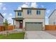 Two-story home featuring a two-car garage, green lawn, and stone details at 17969 Dandy Brush Ln, Parker, CO 80134