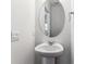 Stylish half bathroom with pedestal sink, oval mirror and clean, modern finishes at 17969 Dandy Brush Ln, Parker, CO 80134