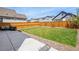 Spacious backyard with a lush green lawn, concrete patio, and wooden fence at 27857 E 8Th Ave, Aurora, CO 80018