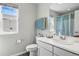 Bright bathroom featuring a large mirror, vanity with sink, and fresh, neutral colors at 27857 E 8Th Ave, Aurora, CO 80018