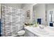 Well-lit bathroom featuring a modern vanity, decorative shower curtain, and stylish mirror at 27857 E 8Th Ave, Aurora, CO 80018