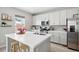 Modern kitchen with stainless steel appliances, island with stools, and ample countertop space at 27857 E 8Th Ave, Aurora, CO 80018