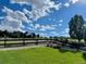 Picturesque view of a lush lawn and open field under a clear blue sky, complemented by a wooden fence at 22026 Hill Gail Way, Parker, CO 80138