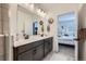 Bathroom featuring double sinks, a large mirror, dark cabinets, and tile flooring at 7885 Yampa River Ave, Littleton, CO 80125