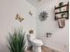 Well-lit half bathroom with a toilet, decor, modern fixtures, and decorative shelving at 7885 Yampa River Ave, Littleton, CO 80125