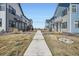 A well-kept community with neat landscaping and walkways between modern townhomes beneath a clear blue sky at 7885 Yampa River Ave, Littleton, CO 80125