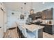 Modern kitchen with stainless steel appliances, pendant lighting, and a spacious island with bar seating at 7885 Yampa River Ave, Littleton, CO 80125