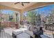 Covered outdoor deck with comfortable seating and a view of the surrounding greenery at 9617 Silent Hills Ln, Lone Tree, CO 80124