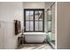 Elegant bathroom with a freestanding tub, large window, and glass-enclosed shower at 1291 S Gaylord St, Denver, CO 80210
