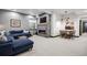 Basement living room with fireplace, tv, and cozy blue sectional couch at 1291 S Gaylord St, Denver, CO 80210